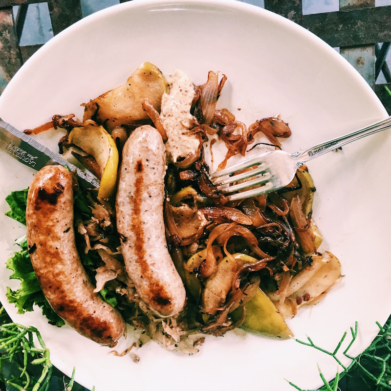 Autumnal meal of sausages, apples, and sauerkraut
